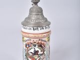 a beer mug with a statue on top of it