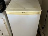 a white refrigerator and a microwave in a small room