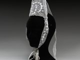 une coiffe de mannequin noire ornée d'un voile en dentelle blanche