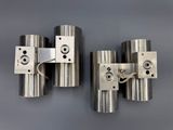 three stainless steel cylinders are mounted on a gray surface