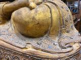 a gold statue of a person sitting on a table