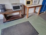 deux micro-ondes et une table dans une petite pièce