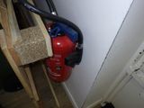 un extincteur fixé au mur à côté d'une borne d'incendie