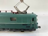 a green train with a crane on top of it