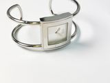montre-bracelet en argent avec un cadran carré sur fond blanc
