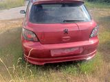 une voiture rouge garée dans l'herbe