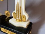 a white and gold vase with a clock on it