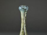 a green and gold vase with a tree design on it