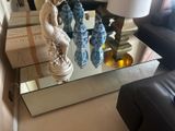une table en verre sur laquelle se trouve une statue, dans un salon