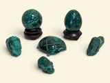 a group of green marbles sitting on top of a white surface