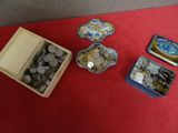 une boîte de pièces et une boîte de boîtes de conserve posées sur une table rouge