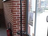 a black coat rack in front of a brick wall