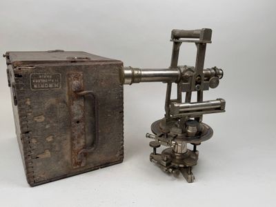 une vieille boîte en métal posée à côté d'une machine en métal sur une surface blanche