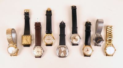 plusieurs types de montres sont alignés sur une surface blanche