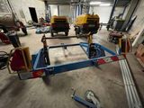 a small trailer with a crane attached to it in a garage