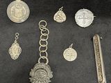 some silver jewelry is laying out on a black surface