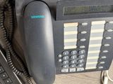 a telephone that is sitting next to a keyboard on a desk