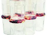 six bocaux en verre transparent avec couvercle, remplis de fruits et de baies