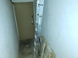 une échelle appuyée contre un mur dans une pièce étroite