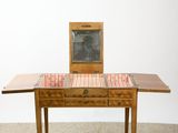 a small wooden table with a mirror on top of it