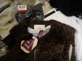 a pile of clothes and a jacket on a bed
