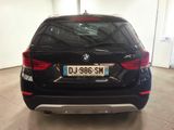 the back of a black bmw suv parked in a garage