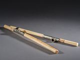 pair of bamboo sticks with a silver handle on a gray surface