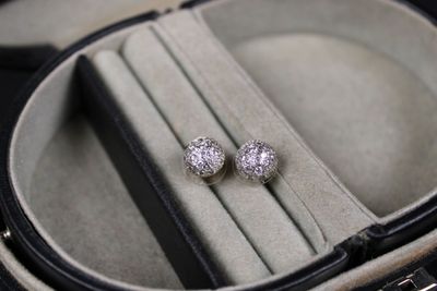 a pair of diamond stud earrings in a case