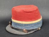 un chapeau rouge orné d'un ruban bleu et un chapeau gris orné d'un ruban jaune