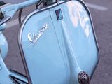 a blue scooter that is parked on the side of the road