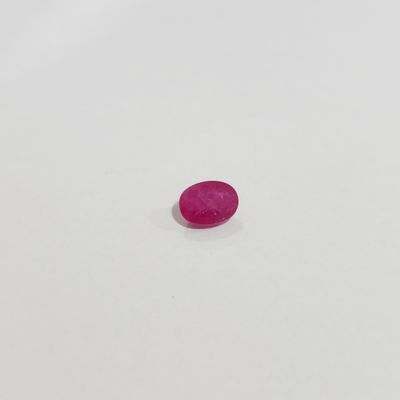 a pink oval shaped stone on a white surface