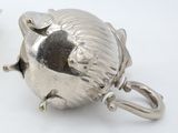 a silver teapot and a teacup on a white table