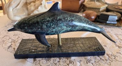 statue of a dolphin on a marble base on a table