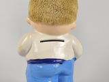 a small figurine of a boy holding a piggy bank