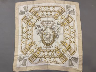 a white and gold square scarf with a picture of a lion on it
