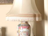 a lamp that is sitting on a table with a cup and saucer