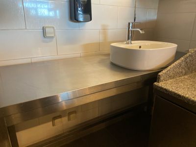 un lavabo et un plan de travail dans des toilettes publiques