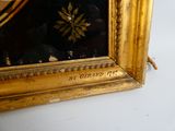 une photo d'un cadre doré sur lequel est posée une horloge
