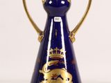 a blue and gold vase with a crown on it