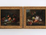 deux tableaux représentant des fruits et des fleurs posés sur une table dans une pièce