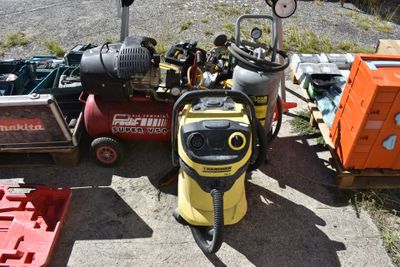 a yellow and black pressurer sitting on the ground next to other tools