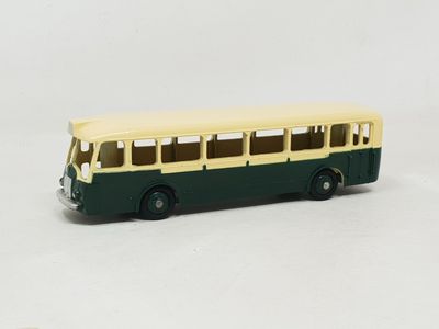 un petit bus en jouet posé sur une surface blanche