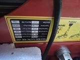 a close up of a red tractor with a hose attached