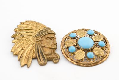deux broches en or et turquoise sur un fond blanc