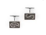 une paire de boutons de manchette en forme de diamants noirs et blancs sur fond blanc