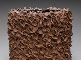 un gros plan d'un vase marron posé sur une surface grise
