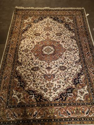 un tapis oriental exposé dans une pièce au sol marron