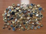 a pile of buttons on a table with a wooden surface