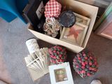 une boîte contenant divers objets, posée par terre à côté d'une paire de chaussures