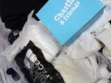 a stuffed animal that is laying on a bed with a box